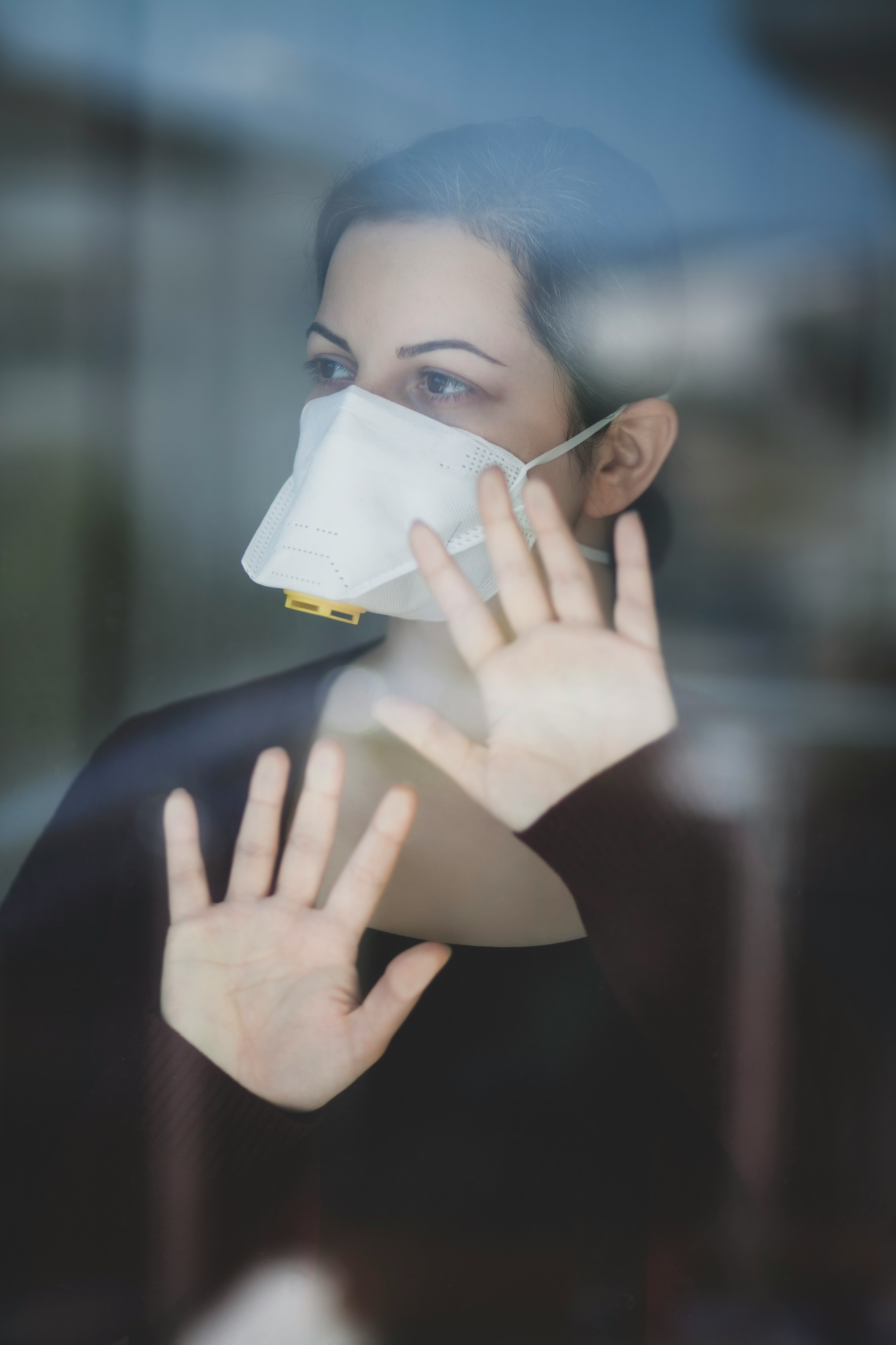 woman in black shirt covering face with white paper